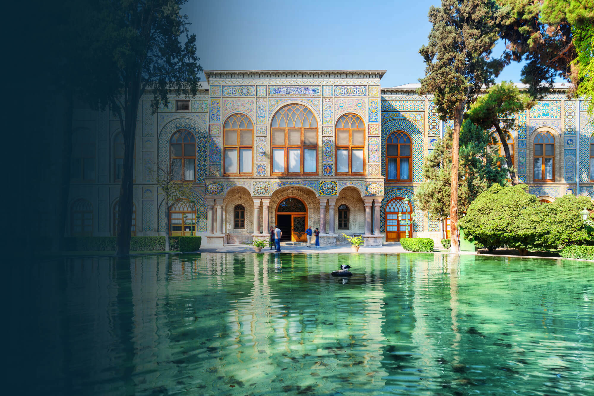 Ein Bild vom Golestan-Palast in Teheran, umgeben von Blumen und einem Teich.