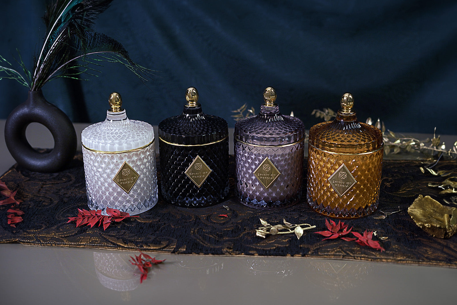 Unsere hochwertigen vier Duftkerzen der Kollektion „Journey to Persia" stehen nebeneinander auf einem orientalisch dekorierten Tisch.