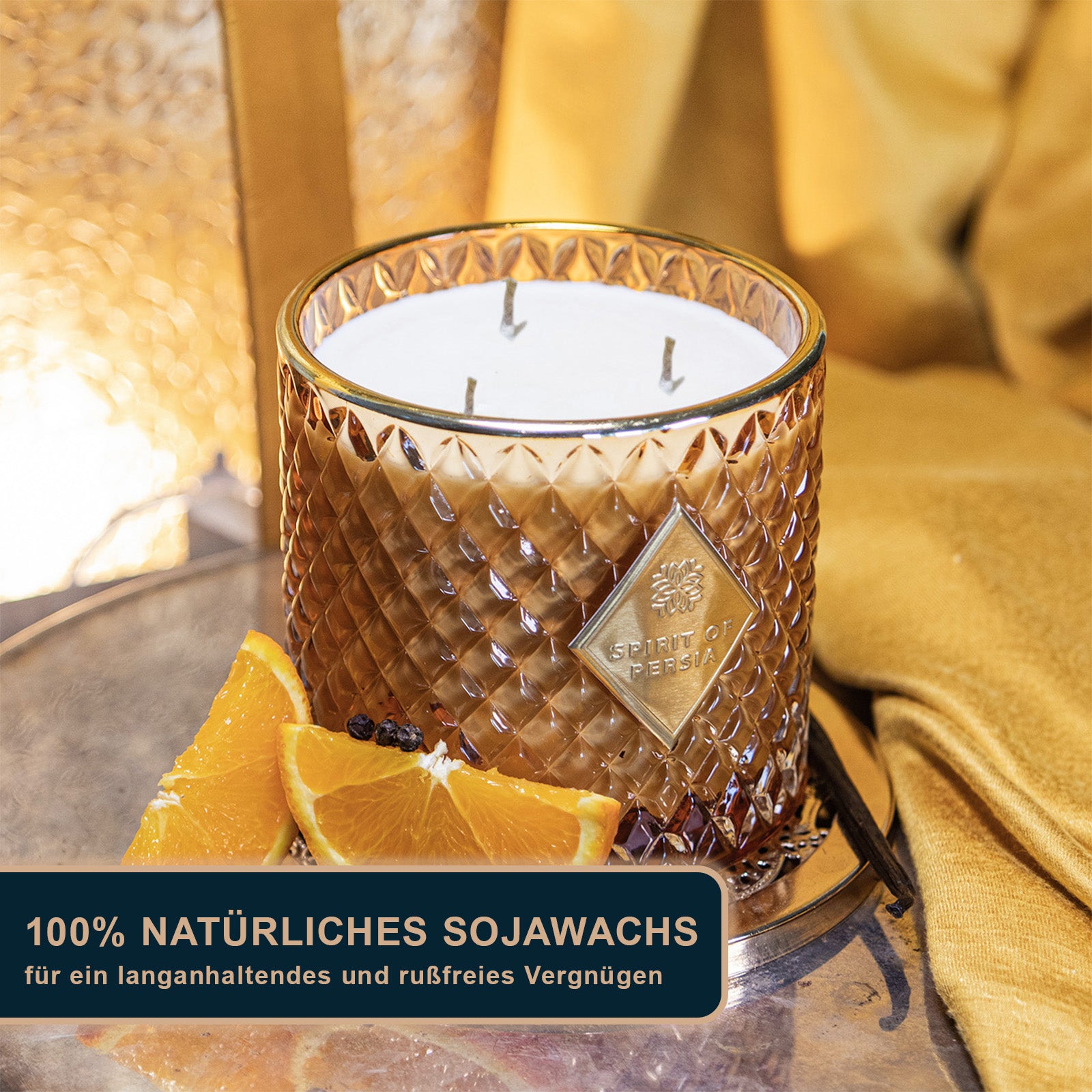 Unsere hochwertige Duftkerze Yazd auf einem goldenen Podest mit goldenen Ornamenten als Hintergrund.